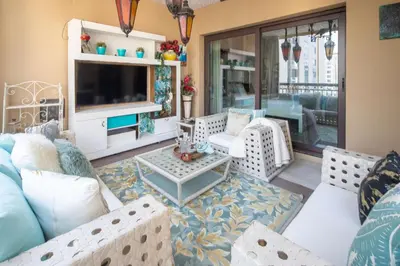 a living room with a couch and a tv at Frank Porter - Fairmont Residence South in Dubai