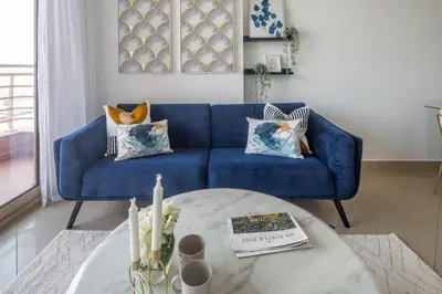 a blue couch in a living room with a table at Frank Porter - Icon Tower 1 in Dubai