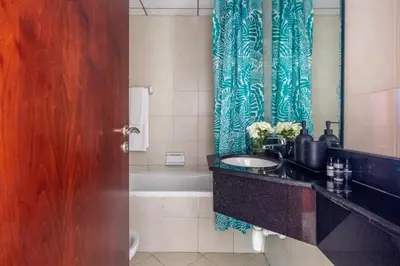 a bathroom with a sink and a blue shower curtain at Frank Porter - Icon Tower 1 in Dubai