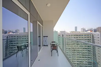 a balcony with chairs and tables on a building at Distinguished 1BR at Vera Tower Business Bay by Deluxe Holiday Homes in Dubai