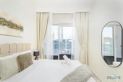 a white bedroom with a large bed and a mirror at Distinguished 1BR at Vera Tower Business Bay by Deluxe Holiday Homes in Dubai