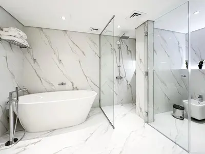 a white bathroom with a tub and a glass shower at Relaxing 1 bedroom apartment at 5 Star Resort in Dubai
