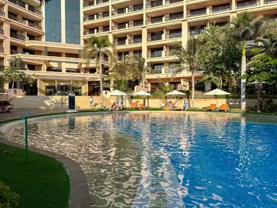 a large swimming pool in front of a large building at Relaxing 1 bedroom apartment at 5 Star Resort in Dubai