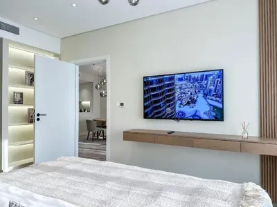 a bedroom with a tv on a white wall at Relaxing 1 bedroom apartment at 5 Star Resort in Dubai