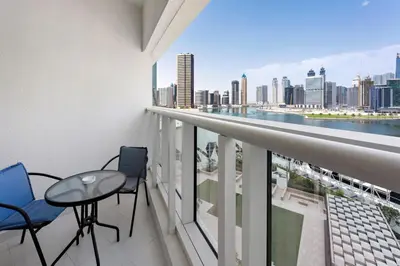 a balcony with a table and chairs and a view of the city at ALiving Modern 1BR Apartment with Balcony & Canal View I DAMAC Maison Prive A- 517 in Dubai