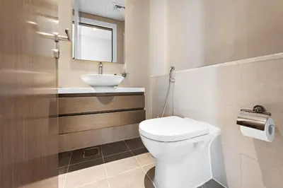 a bathroom with a white toilet and a sink at ALiving Modern 1BR Apartment with Balcony & Canal View I DAMAC Maison Prive A- 517 in Dubai
