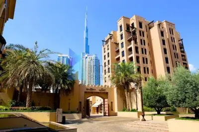 a building with palm trees and buildings in a city at Burj Dubai Area - 5min Walk - Luxury 2 Bedroom Apartment in Dubai