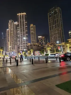a city skyline at night with cars in a parking lot at Burj Dubai Area - 5min Walk - Luxury 2 Bedroom Apartment in Dubai