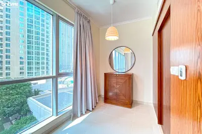 a room with a large window and a mirror at bnbme - Luxury 2BR Near Burj Khalifa Apt Balcony Pool Gym Concierge Near Dubai Mall in Dubai