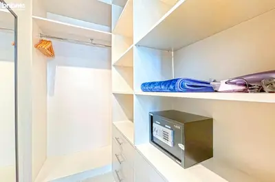 a walk in closet with a tv and shelves at bnbme - Luxury 2BR Near Burj Khalifa Apt Balcony Pool Gym Concierge Near Dubai Mall in Dubai