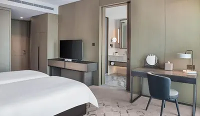 a bedroom with a bed and a desk and a television at Address Creek Harbour in Dubai