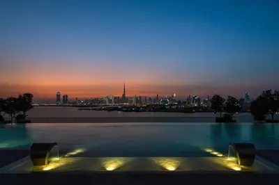a pool with a view of the city at dusk at Address Creek Harbour in Dubai