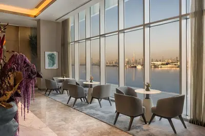 a room with tables and chairs and a large window at Address Creek Harbour in Dubai