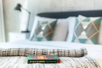 a book sitting on the edge of a bed at The Smart Concierge - Marina Scape in Dubai