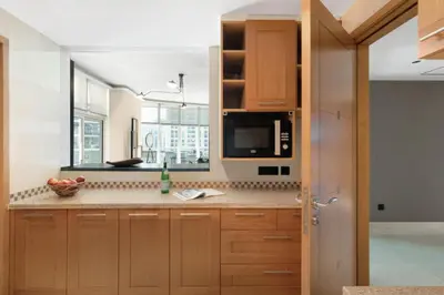 a kitchen with wooden cabinets and a microwave at The Smart Concierge - Marina Scape in Dubai