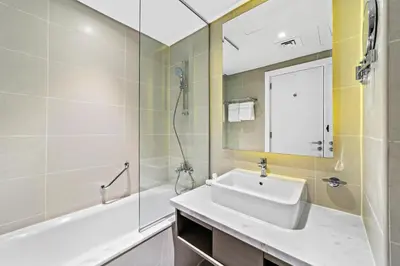 a bathroom with a sink and a tub and a mirror at ALiving Luxury Studio with Canal Views I DAMAC Maison Prive 2512 in Dubai