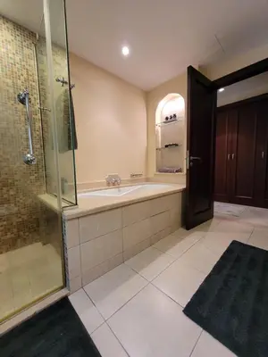 a bathroom with a shower and a tub and a sink at Luxury 3 Bedroom Apartment - DUBAI MALL 5 min Walk in Dubai