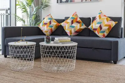 a blue couch with two tables in a living room at Panoramic Burj Views - Lovely 3BR in Creek Harbour in Dubai