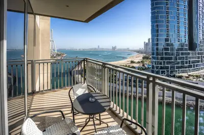 a balcony with chairs and a view of the ocean at Lovely 1BD canal view apartment in Dubai Marina in Dubai