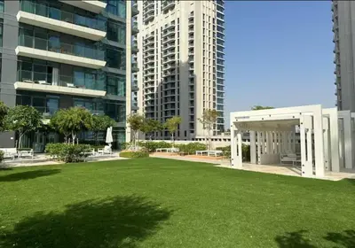 a large green field in front of a building at Lovely 1 BD apartment in Beach Vista Tower in Dubai