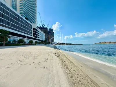 a beach with footprints in the sand next to the water at Lovely 1 BD apartment in Beach Vista Tower in Dubai