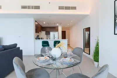 a dining room with a glass table and chairs at HiGuests - Spacious Apt Near Zabeel Park With Panoramic Views in Dubai
