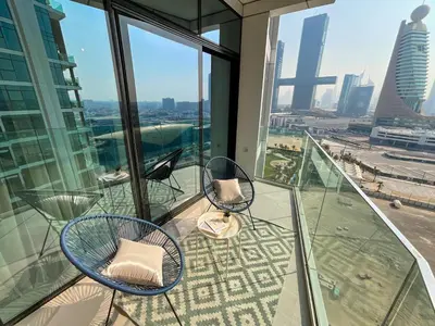 a balcony with two chairs and a view of the city at HiGuests - Spacious Apt Near Zabeel Park With Panoramic Views in Dubai
