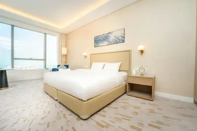 a large bedroom with a large white bed and large windows at FAM Living - Palm Tower - Palm Jumeirah - Panoramic Studios in Dubai