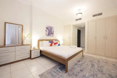 a bedroom with a bed and a dresser and a mirror at RH- Lovely 1BR apartment in JLT, near metro in Dubai