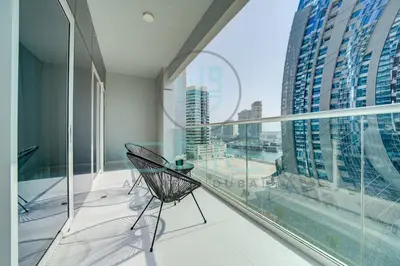 a balcony with a chair and a view of a city at Elegant 1BR with Sofa Bed Close to Metro in Dubai