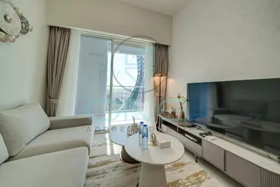 a living room with a couch and a tv at Elegant 1BR with Sofa Bed Close to Metro in Dubai