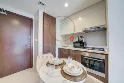 a kitchen with a table with plates on it at Elegant 1BR with Sofa Bed Close to Metro in Dubai