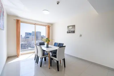 a dining room with a table and chairs and a window at RH- Bright 1BR in JVC, near Circle mall in Dubai
