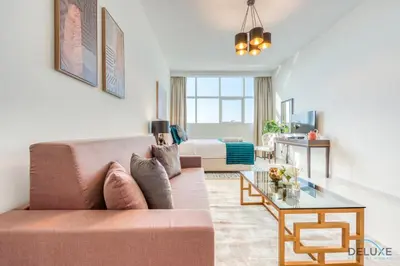 a living room with a couch and a bed at Intimate Studio in Damac Ghalia Jumeirah Village Circle by Deluxe Holiday Homes in Dubai