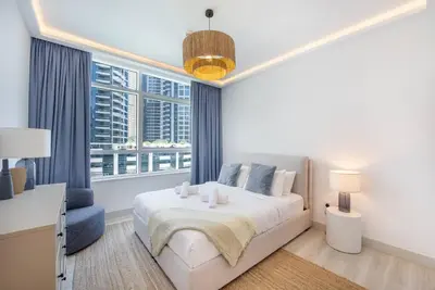 a white bedroom with a bed and a window at Astonishing 3BDR in the heart of Dubai Marina in Dubai