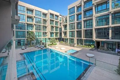 a swimming pool in front of a building at Modern flat with KING SIZE bed and HIGH SPEED Wifi in Dubai
