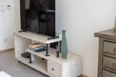 a television on a wooden stand with a vase on it at Fantastic Studio resort style facilities - OFFER in Dubai