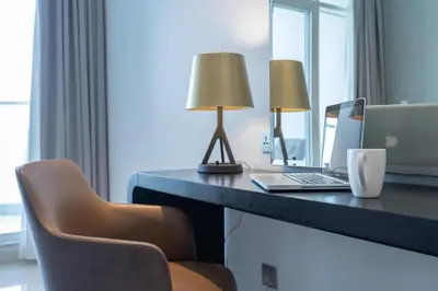 a room with a desk with a laptop and a chair at Spectacular Burj Khalifa view service apartment in Dubai