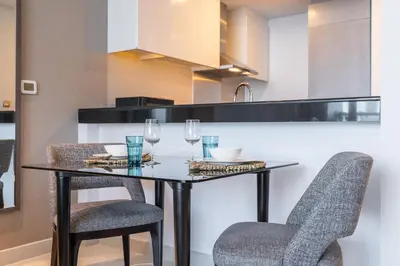 a kitchen with a table with two chairs and wine glasses at Spectacular Burj Khalifa view service apartment in Dubai