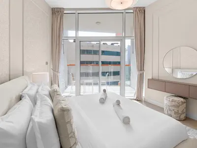 a living room with a white couch and a large window at Cozy Retreat 1Bedroom on the Business Bay Canal by Suiteable Interiors in Dubai