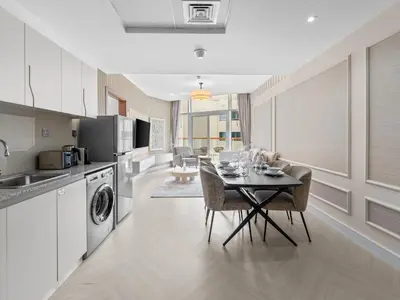 a kitchen and dining room with a table and chairs at Cozy Retreat 1Bedroom on the Business Bay Canal by Suiteable Interiors in Dubai