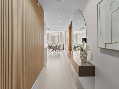 a hallway with white walls and a vase of flowers at Cozy Retreat 1Bedroom on the Business Bay Canal by Suiteable Interiors in Dubai