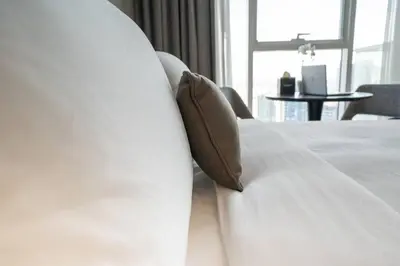 a white bed with two pillows on top of it at At The Top Burj View STUDIO - Special offer in Dubai