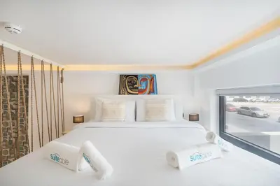 a bedroom with a large white bed and a window at Unique loft with smart working station in Dubai
