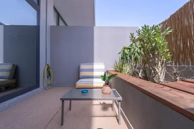 a patio with a bench and a table and a chair at Unique loft with smart working station in Dubai
