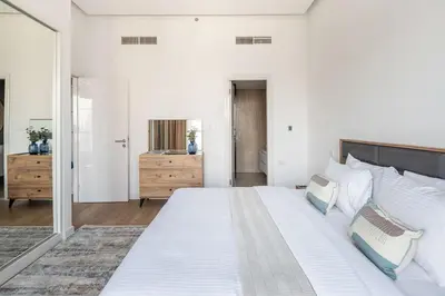 a white bedroom with a large white bed and a mirror at Frank Porter - Bay Central Tower 1 in Dubai