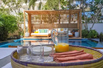 a tray of food and orange juice on a table near a pool at Private Pool Apt. Five Palm Jumeirah up to 6guest in Dubai