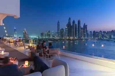 a view of a city skyline at night from a balcony at Private Pool Apt. Five Palm Jumeirah up to 6guest in Dubai