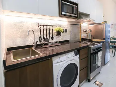 a kitchen with a sink and a washing machine at Elite LUX Holiday Homes - Modern Style Studio Superior Facilities in Arjan Dubai in Dubai