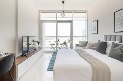 a white bedroom with a large bed and a couch at Frank Porter - Carson Tower C in Dubai